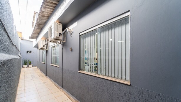 A narrow corridor with tiled flooring, a grey wall, and a window with vertical blinds. - Kitnet 20% off, Full Kitchen, up to 4 Guests, Jr Catito (Brasília)