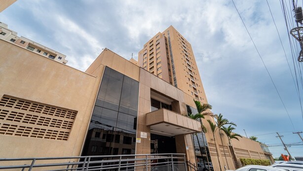 A modern building with a prominent entrance, large windows, and a tall structure adjacent to it. - Up to 5 Guests, Garage, Elevator, Swimming Pool, Jr Catito (Brasília)