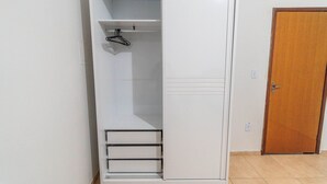 A white wardrobe with a hanging rod and a door. - Ap 75m2, 2 Bedrooms/suite, Up to 7 Guests, WI-FI 1G, Jr Catito (Brasília)