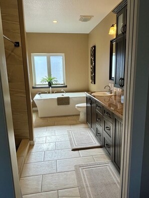 A modern bathroom with a freestanding bathtub, a vanity with a sink, and a toilet. - Alpine Adventure at Jasper East Gates (Folding Mountain Village)