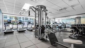 A modern gym with treadmills, weight machines, and dumbbells. - Amazing Studio Downtown MIA (Miami)
