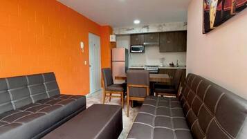 Departamento, varias camas, cocineta, vista a la ciudad | Área de sala de estar