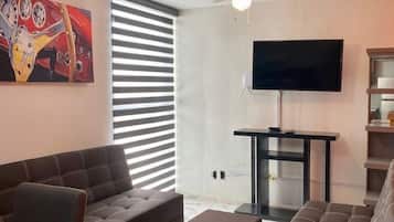 Departamento, varias camas, cocineta, vista a la ciudad | Área de sala de estar