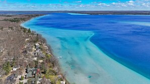 A coastal area with clear blue waters, a small settlement with houses, and a dock. - Lake View Fully Stocked Family Retreat - Paddleboards, Firepit, Games, EV outlet (Roscommon)
