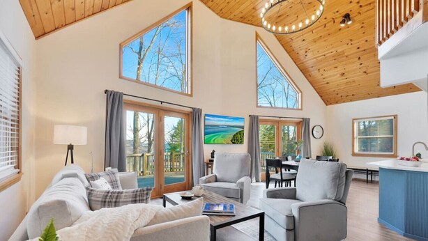 A spacious living room with a high ceiling, large windows, and a view of the outdoors. - Lake View Fully Stocked Family Retreat - Paddleboards, Firepit, Games, EV outlet (Roscommon)