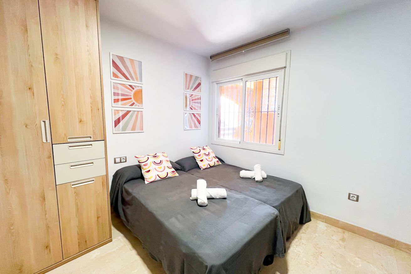 A bedroom with a bed, a wardrobe, and artwork on the wall.