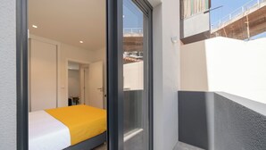 A bedroom with a bed, a sliding glass door, and a view of the outside. - Holidays in Funchal - Golden City B (Funchal)