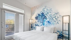 Une chambre avec un grand lit, une vue à travers la porte et une fresque murale.