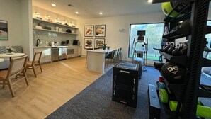 Eine moderne Küche mit Essbereich, Laufband und Krafttrainingsgeräten.