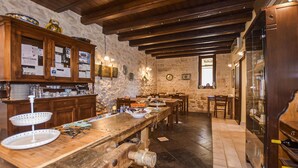 A rustic kitchen with wooden beams, stone walls, and a long wooden counter with various kitchen items. - Gorgeous home in Santa Croce Camerina (Santa Croce Camerina)