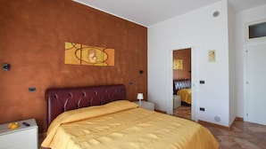 Ein Schlafzimmer mit einem großen Bett, einem Kopfteil, einem Nachttisch und einem Wandbild.