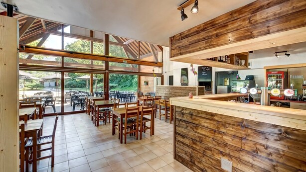 A spacious café with wooden furniture, large windows, and a bar area with coffee machines. - Motz | Edge of Natura 2000 | Unique Apt | Sleeps 6 (Motz)