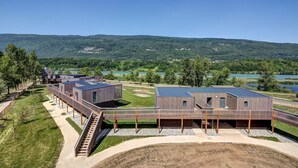A modern building complex with multiple structures, a covered walkway, and a scenic view of hills and a lake. - Motz | Edge of Natura 2000 | Unique Apt | Sleeps 6 (Motz)