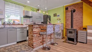 Una cocina moderna con una pared de ladrillo decorativa, una isla central, taburetes de bar y una estufa empotrada.