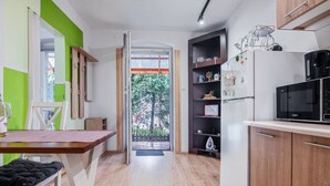 A modern kitchen with wooden cabinets, a built-in microwave, and a refrigerator. - 2 osobowy by Interhome (Warnowo)