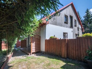 A house with a wooden deck, a fenced yard, and a satellite dish. - 2 osobowy by Interhome (Warnowo)
