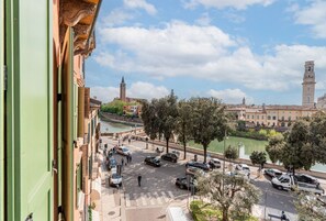 A view of a river with buildings and a tower in the background. - Ponte Pietra Residence (Verona)