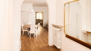 A modern interior with a dining area, a large mirror, and a radiator. - Serego Residence - Elegant residence overlooking Porta Leoni (Verona)