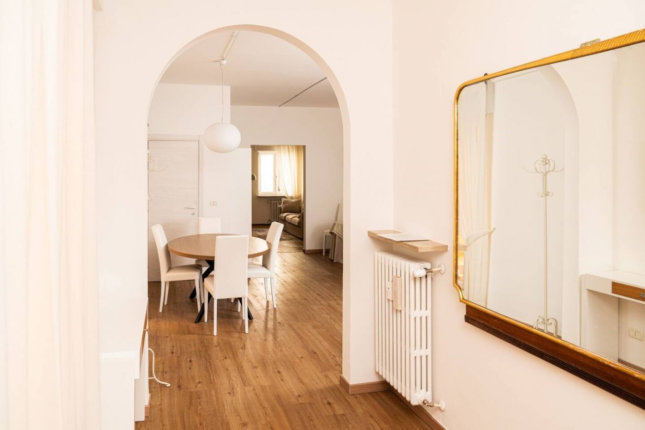 Un intérieur moderne comprenant un coin repas, un grand miroir et un radiateur.