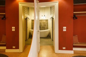 A bathroom with a freestanding bathtub, a towel rack, and a shower area. - Comfortable Satyr Residence (Verona)