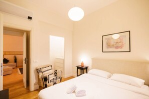 A bedroom with a bed, a chair, a nightstand, and a wall-mounted picture. - Spacious and elegant Satyr residence with terrace (Verona)