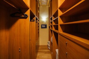 A narrow wooden closet with multiple shelves and drawers, a hanging rack, and a light fixture on the ceiling. - Spacious and elegant Satyr residence with terrace (Verona)