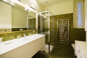 A bathroom with a glass-enclosed shower, a white sink, and a tiled backsplash. - Luxurious Stella residence with balcony overlooking Arena (Verona)
