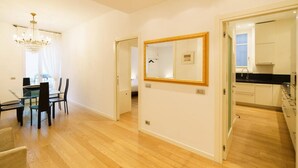 Ein modernes Interieur mit Essbereich, einem großen Spiegel und einer Küche.