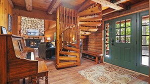 A wooden interior with a spiral staircase, a piano, and a stone fireplace. - The Lodge at Geneva Lake |Golf Cart |Impressive Log Cabin |Deck |Abbey Springs |Beach |Pools (Fontana-on-Geneva Lake)