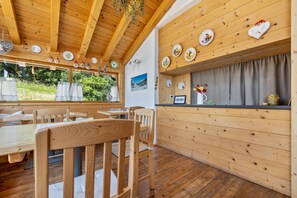 A wooden interior with a dining area, wooden ceiling, and wall-mounted plates.