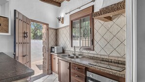 A kitchen with a granite countertop, stainless steel sink, and a built-in oven.