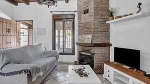 A living room with a sofa, a fireplace, a television, and a coffee table.