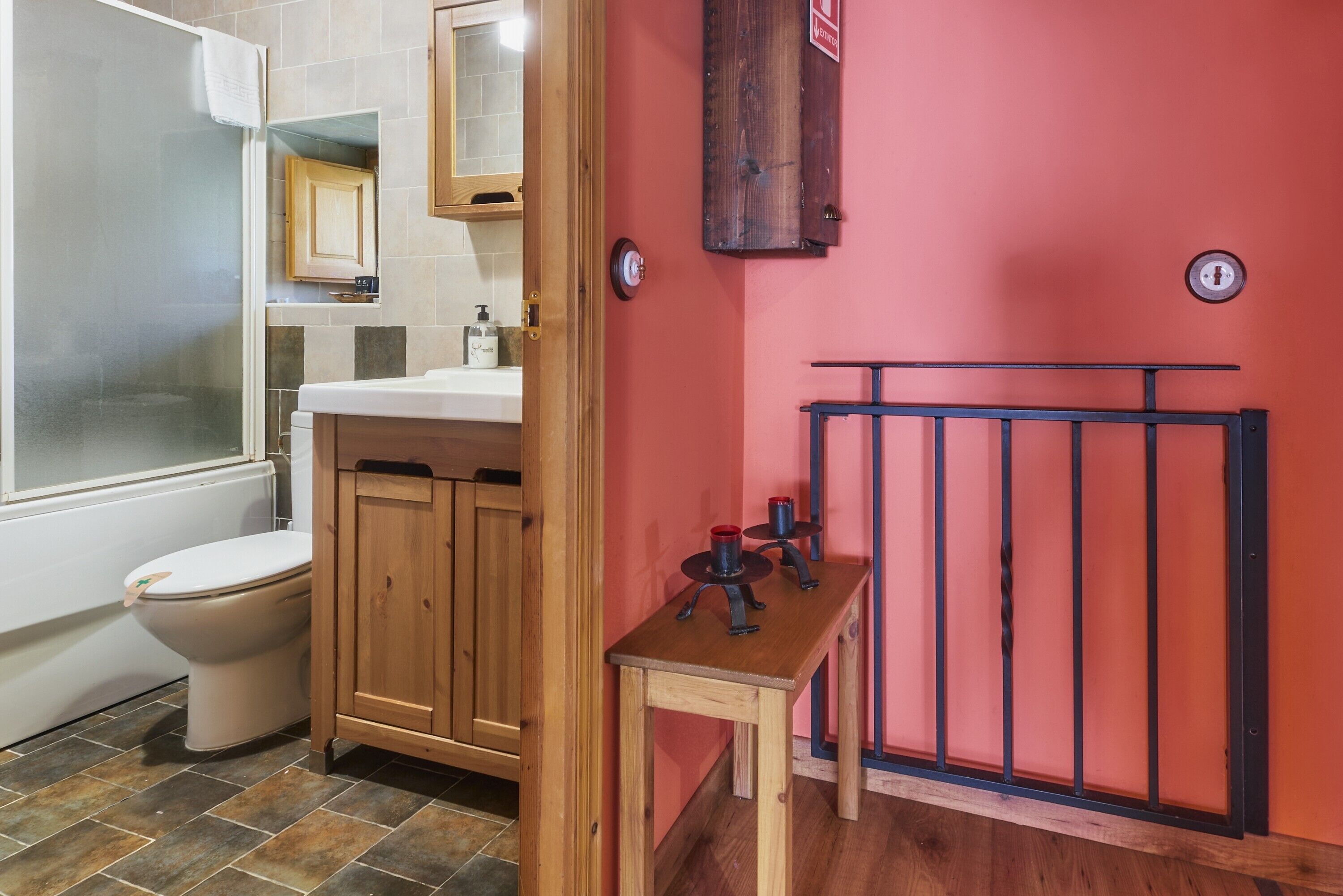 Un bagno con il water, armadietti in legno, un lavandino, uno specchio e un box doccia.