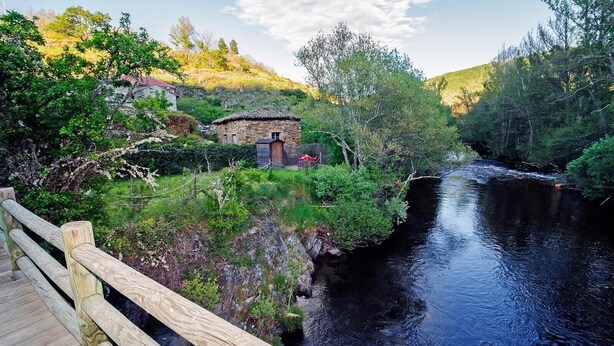 A wooden bridge over a river with a stone building and greenery in the background. - Country Home 'Aguas Frias 2' with Mountain View, Private Terrace and Wi-Fi (La Omañuela)
