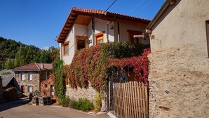 A stone building with a red-tiled roof, a wooden fence, and a clear blue sky. - Country Home 'Aguas Frías I' with Mountain View, Private Terrace and Wi-Fi (La Omañuela)