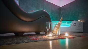 Een massagestoel, een fles champagne en een kleine tafel met kaarsen in een spa.