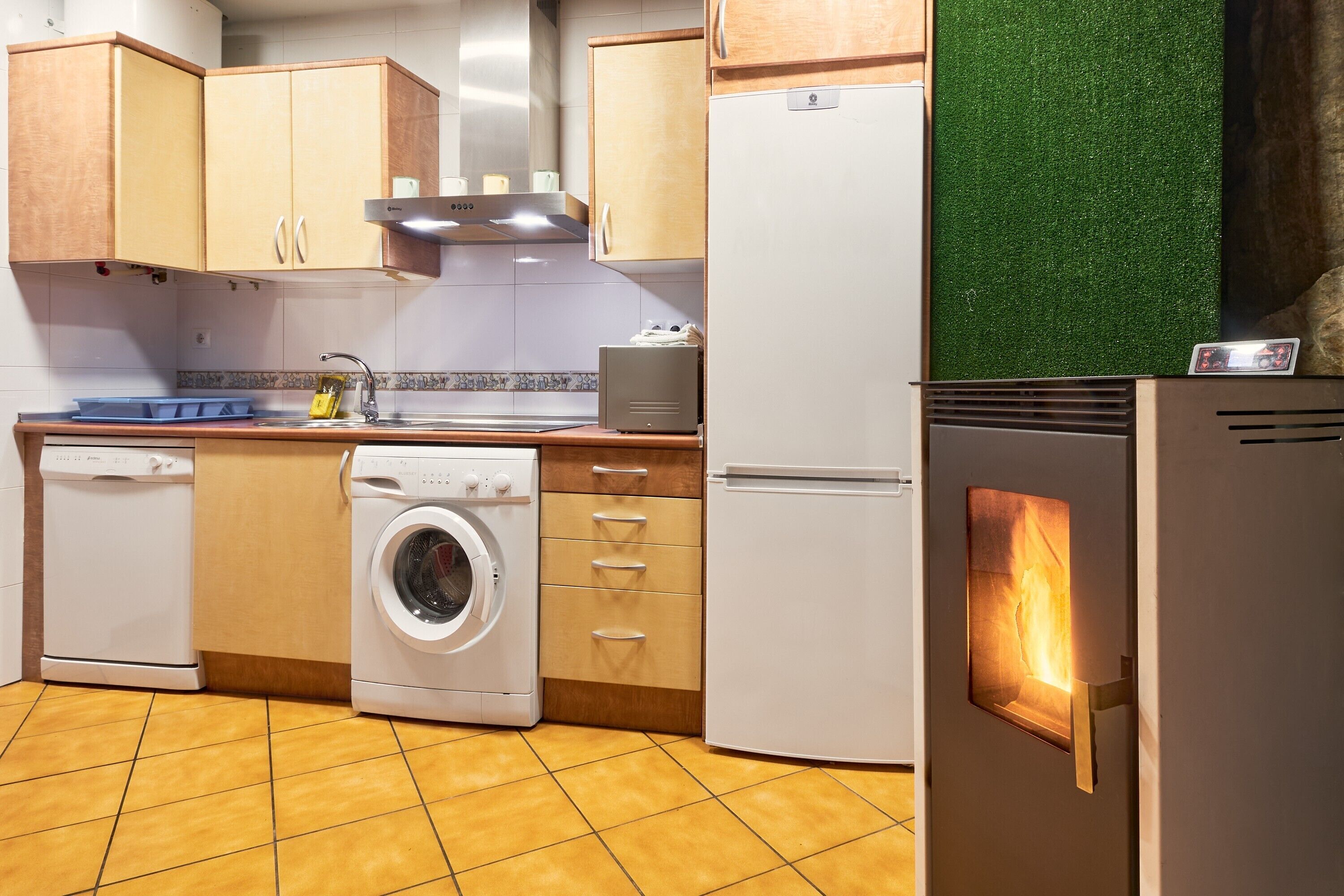 A kitchen with a washing machine, a refrigerator, and a microwave.
