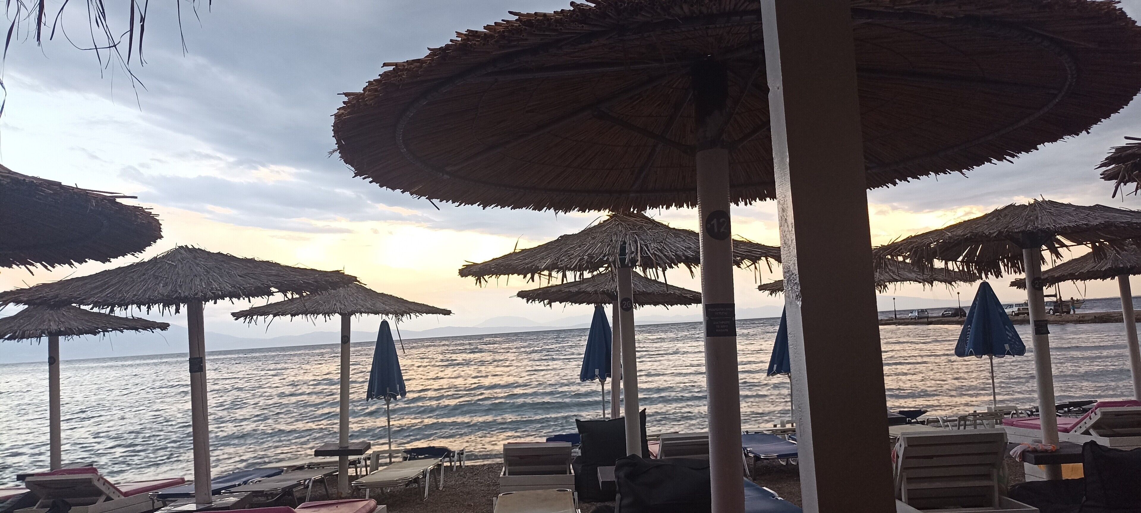 Strandstühle, Sonnenschirme und Meerblick.