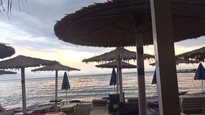 Beach umbrellas, lounge chairs, and a view of the sea.