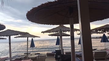 Strandstühle, Sonnenschirme und Meerblick.