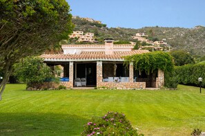 A house with a stone facade, a tiled roof, and a garden in front. - Holiday Home 'Villa Tiziana' with Sea View, Wi-Fi and Air Conditioning (Costa Rei)