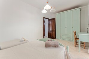 Un dormitorio con cama, escritorio y armario.