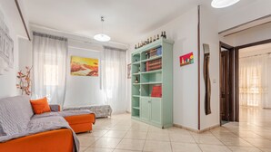 Ein Wohnzimmer mit einer Couch, einem Bücherregal und einem Gemälde an der Wand.