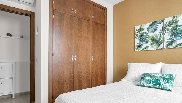 Une chambre à coucher comprenant un lit, une armoire et une œuvre d’art accrochée au mur.