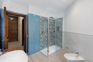 A bathroom with a shower, a sink, and a wooden door. - Apartment 'Appartamento Sorrento' with Sea View, Wi-Fi, and Air Conditioning (Massa Lubrense)