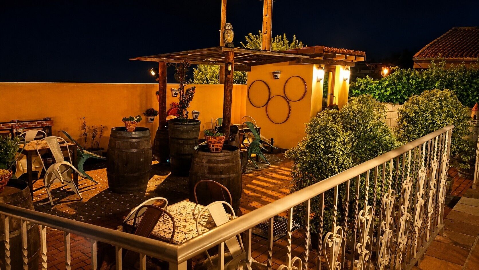 Un espacio al aire libre con área de estar, plantas en macetas y detalles decorativos.