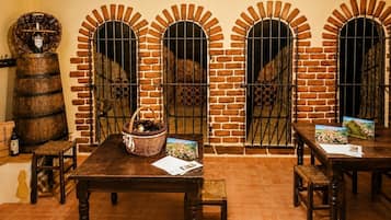 Un interior rústico con arcos de ladrillo, mesas y bancos de madera.