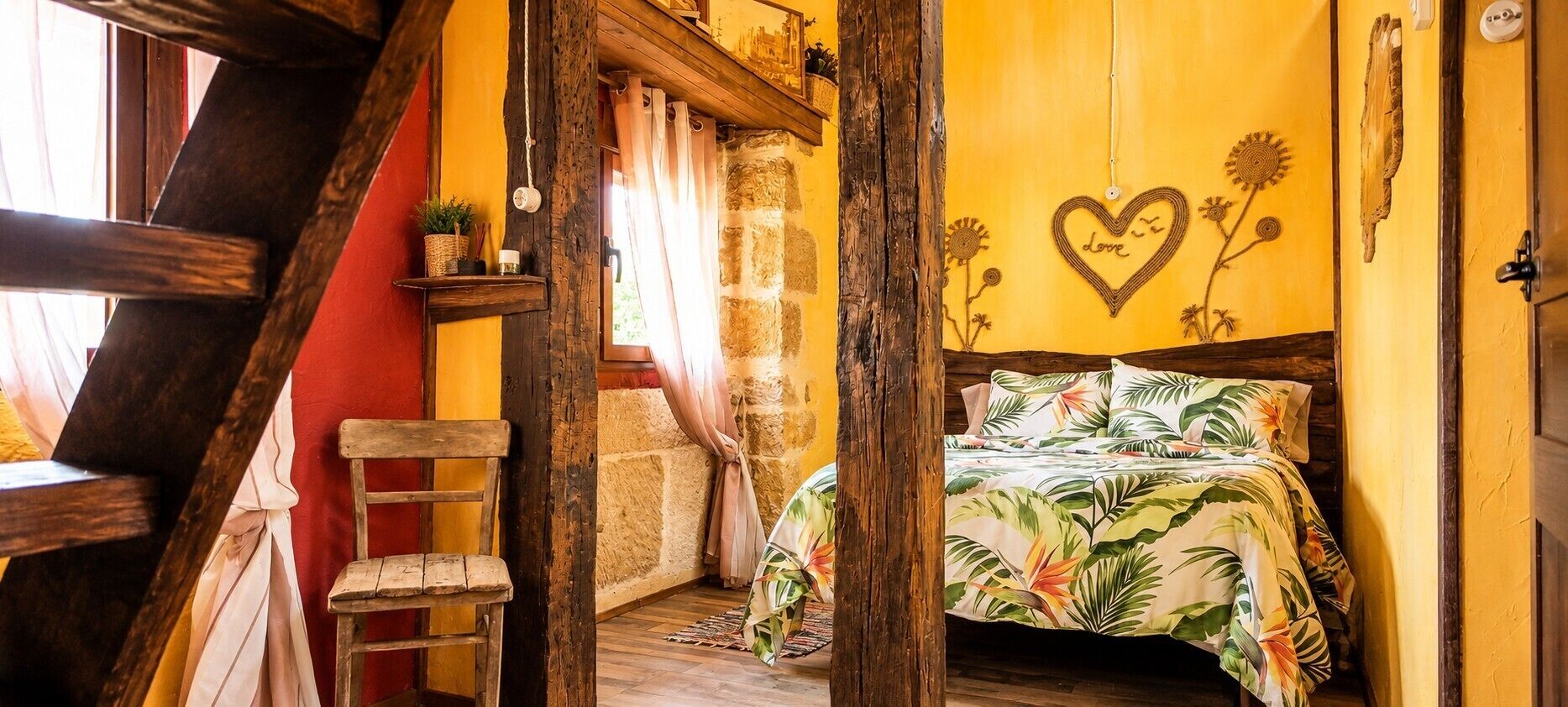 Una habitación rústica con una cama de madera, una silla y una escalera de madera.