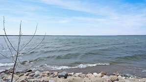 A rocky shoreline with a clear view of the sea and a distant horizon. - Ottertail Lakefront 3BR. Boat lift. Cozy. Awesome! (Ottertail)