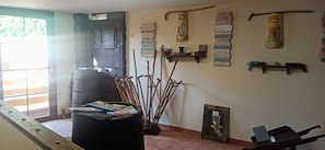 Une pièce comprenant un banc en bois, un pouf noir, un tableau encadré et un mur orné d’affiches inspirantes.